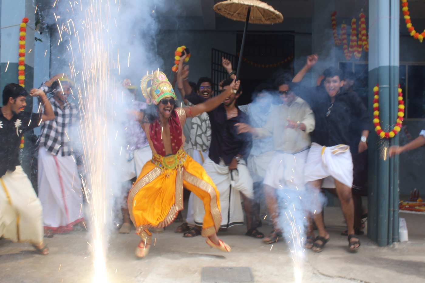 A resident dressed as King Mahabali making a grand entrance amid sparklers during Onam 2026 at Ashiana Hostel